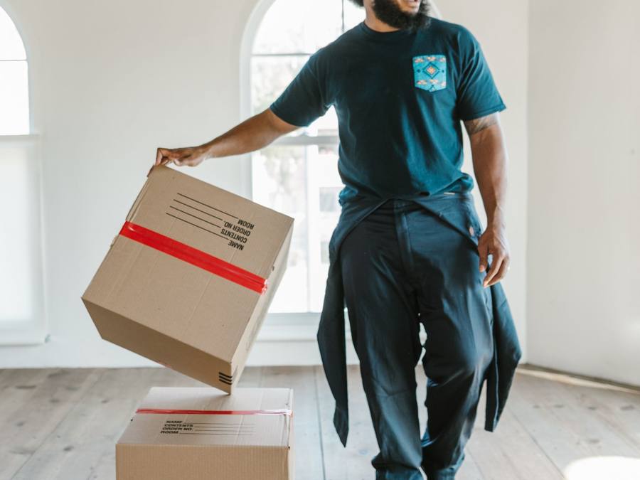 Two Western Provincial Movers wrapping a sofa for a small move in a Calgary condo elevator, Calgary AB